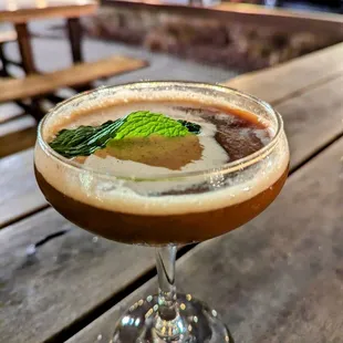 a drink in a glass on a wooden table