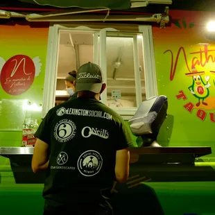 Lexington Sports &amp; Social Club cornhole player ordering from Nathan's Taqueria food truck.