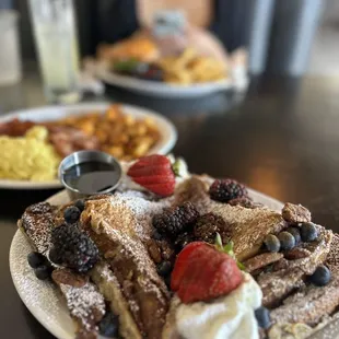 a plate of waffles with strawberries and blueberries