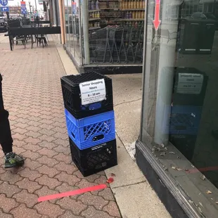 a blue crate and a black crate on the sidewalk