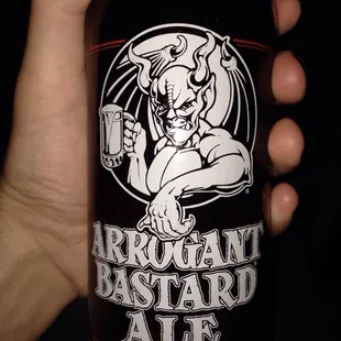 a hand holding a bottle of beer