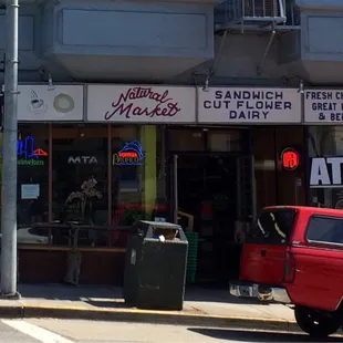 a red truck parked in front of a store