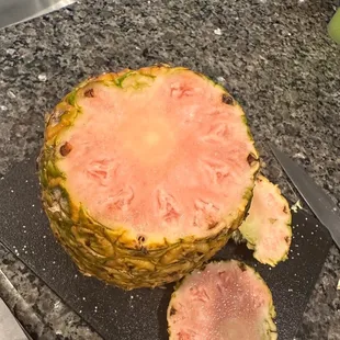a pineapple cut in half on a cutting board