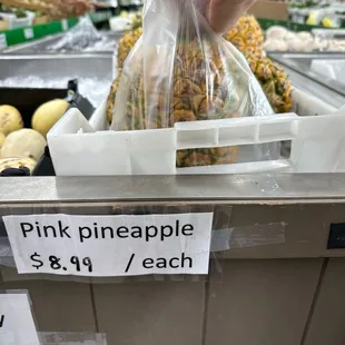 a person picking pineapples from a bin