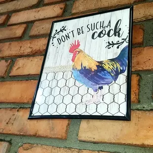 a rooster on a brick wall