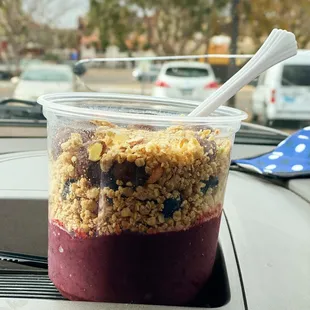a cup of granola with a spoon in it