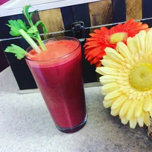 a glass of juice and a flower