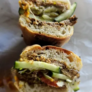 Loaded Butcher's Son Pastrami sandwich complete with vegan cheese, vegan mayo, and sprouts. No vegan tax here!