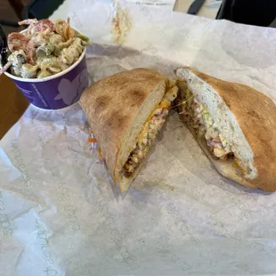 a sandwich cut in half with a side of coleslaw