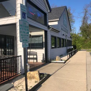 a dog laying on the sidewalk in front of a restaurant