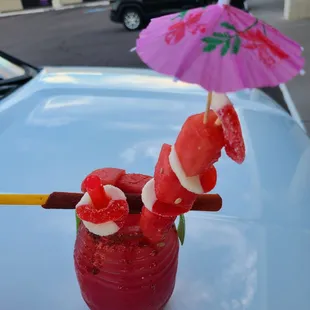 a bloody drink with a pink umbrella