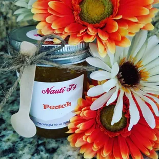 a jar of peach jam and flowers