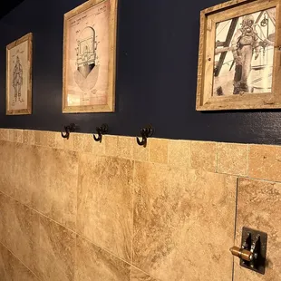 a wall with three framed photographs