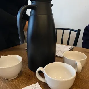 a coffee pot and cups on a table