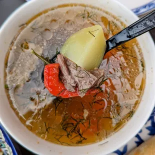 Beef soup Shorpo-Rich aromatic meat broth with chunks of meat, potato, carrots and fresh herbs.