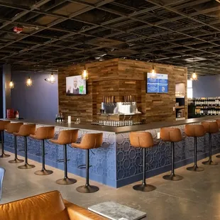 a bar with stools and a television