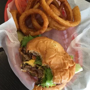 a hamburger and onion rings in a basket