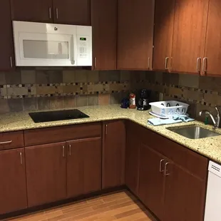 Nice large kitchen with stove, fridge, microwave, dishwasher, and dishes.