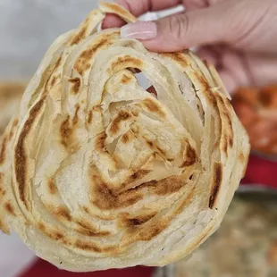 a hand holding a flatbread