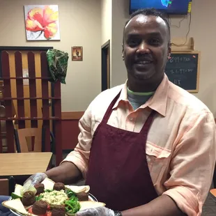 Nawal chef presenting falafel plate to high appreciative diners!
