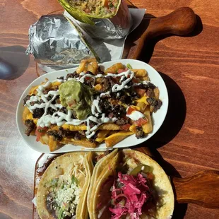 Asada burrito, carne asasa fries, and trio of tacos.