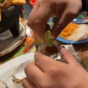 a person grabbing a piece of oyster