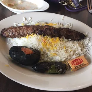 Mini koobideh - single koobideh (ground beef) skewer with saffron white rice and a side of grilled tomato and spicy pepper.