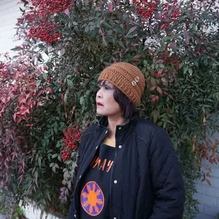 a woman standing in front of a bush