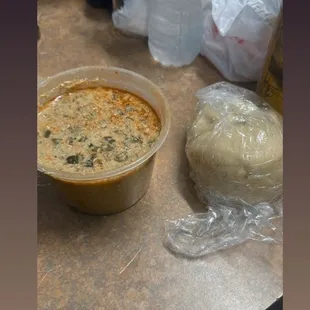 a bowl of soup and a roll of bread