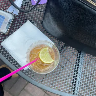 a cup of iced tea with a straw and a lemon slice