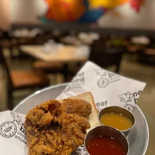 a plate of fried chicken and dipping sauces