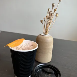 a cup of hot chocolate with an orange on top