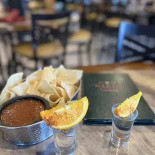 two shot glasses with salsa and chips