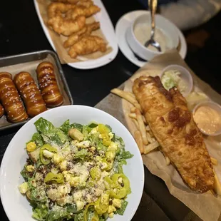 a plate of salad, a bowl of salad, and croissants