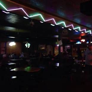 people sitting at tables in a dimly lit bar