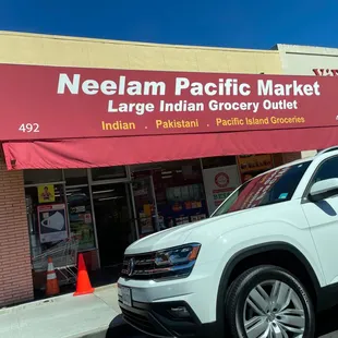 a white volkswagen suv parked in front of a store