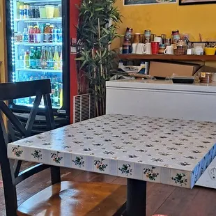 a table and chairs in front of a refrigerator