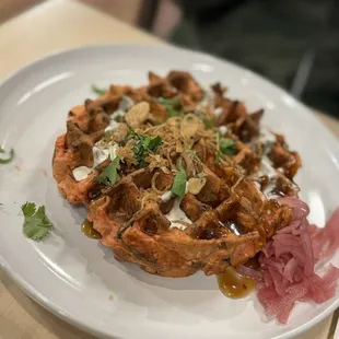 Savory Waffle.  Pork longanisa and bacon, in a savory cabbage mix with calamansi sour cream, sesame dressing, fried garlic, and cilantro.