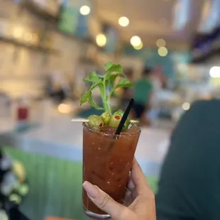 a hand holding a bloody drink