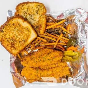 a plate of fried chicken, french fries, and pickles
