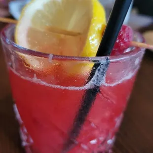 a close up of a drink with a slice of lemon
