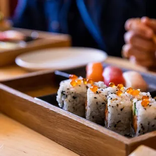 a person eating sushi with chopsticks