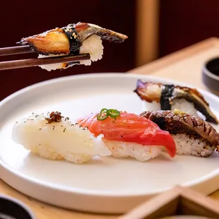 a plate of sushi with chopsticks