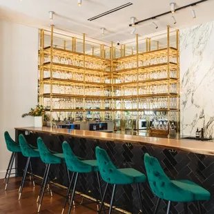 a bar with green velvet chairs