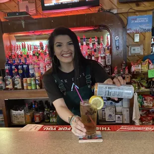 a woman holding a drink and smiling