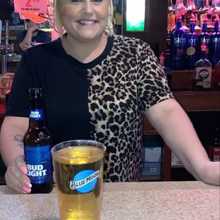 a woman sitting at a bar with a beer