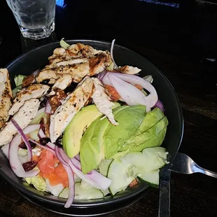 Grilled chicken on top of chopped lettuce, avocados, diced tomatoes, cucumber, red onion, candied pecans, dried cranberries