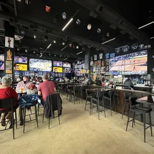 a crowded sports bar with multiple televisions