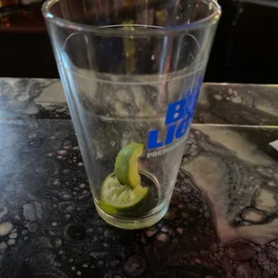 a glass of water with a slice of lime in it