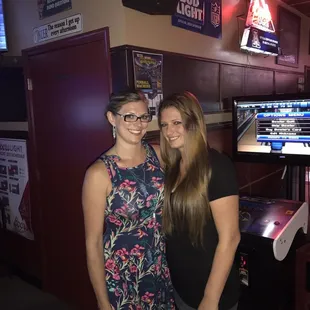 two women standing in front of a television